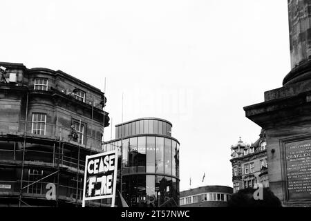 Handgefertigtes Schild mit der Aufschrift „Waffenstillstand“ vor dem Eldon Square und Grey's Monument. Schwarz-weiß. Newcastle upon Tyne, England, Großbritannien - 28. Oktober 2023. Stockfoto