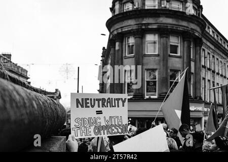 Der Demonstrant hält das handgemachte Schild „Neutralität = Seite mit dem Unterdrücker“ am Grey's Monument hoch. Newcastle upon Tyne, England, Großbritannien - 28. Oktober 2023 Stockfoto