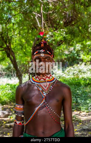 SOUTH HORR, KENIA – 12. FEBRUAR 2020: Junger Mann des Samburu-Stammes, der nach seiner Beschneidungszeremonie einen farbenfrohen Kopfschmuck aus Straußenfedern trägt. Stockfoto