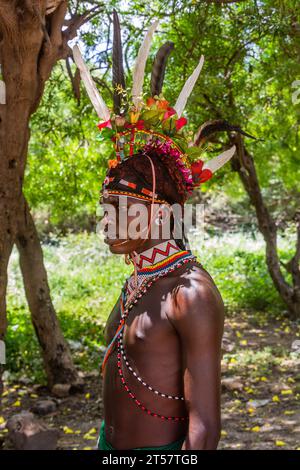 SOUTH HORR, KENIA – 12. FEBRUAR 2020: Junger Mann des Samburu-Stammes, der nach seiner Beschneidungszeremonie einen farbenfrohen Kopfschmuck aus Straußenfedern trägt. Stockfoto