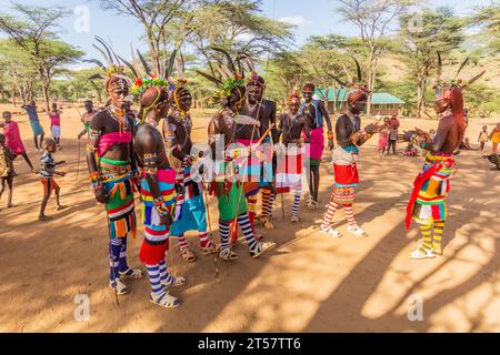 SOUTH HORR, KENIA - 12. FEBRUAR 2020: Gruppe junger Männer aus Samburu, die nach ihrem Zirkus mit bunten Kopfschmuck aus Straußenfedern tanzen Stockfoto