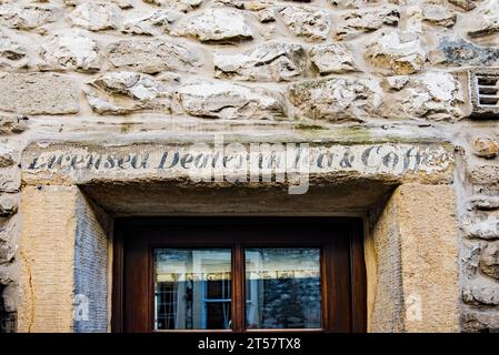 Ein „Geisterschild“ mit verblichener Werbeanzeige mit der Aufschrift „Licensed Dealer in Tea and Coffee“, das auf dem Gelände in Settle North Yorkshire zu sehen ist. Stockfoto