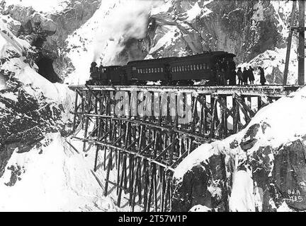 Erster Zug zum White Pass auf der ersten Etappe der White Pass and Yukon Route Railway, Februar 1899. Die Bahn wurde für den Goldrausch von Klondike gebaut, kam aber wegen des Höhenzugs spät. (Anscheinend hat der Zug für das Foto angehalten, beachten Sie die Leute dahinter.) Stockfoto