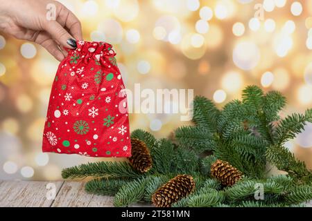 Hintergrund von Weihnachten und Neujahr. Geschenk und Sterne in der Nähe von geschmücktem Weihnachtsbaum an der Wand mit Lichtergirlanden Stockfoto
