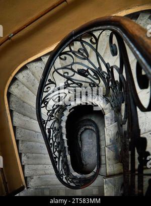 Spiralförmige quadratische Treppe blickte von unten nach oben. Vintage Treppe in alten Mietshaus. Perspektivische Ansicht von unten Stockfoto