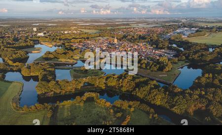 Blick aus der Vogelperspektive auf die historische Stadt Naarden und ihre sternförmigen Kanäle bei Sonnenaufgang. Niederländische Geschichte. Stockfoto