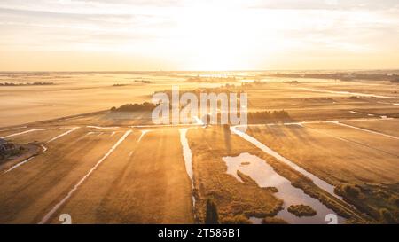 Der Sonnenaufgang beleuchtet die Felder und die niederländische Landschaft in der Nähe der Stadt Zaandam in Mittelholland. Zaanse Schans unter dem orange-roten Inferno. Stockfoto