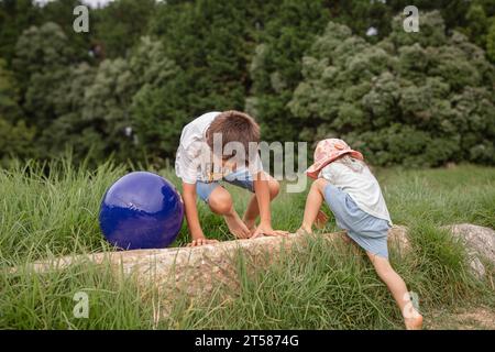 Zwei barfuß kaukasische Kinder spielen in einem grünen Park auf und ab. Das Konzept der glücklichen und sorglosen Kindheit, die Natur erforschen. Stockfoto