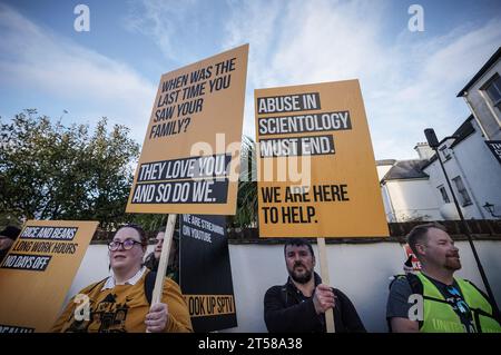 West Sussex, Großbritannien. November 2023. Anti-Scientology-Demonstranten stehen mit Plakaten in der Nähe der Eingangstüren zum britischen Hauptquartier in East Grinstead. Der Protest, der vom Ex-Mitglied Alexander Barnes-Ross organisiert wurde, der sagt, dass er sich den Scientologen im Alter von 15 Jahren im Jahr 2011 angeschlossen hat, lautete, „Scientology eine klare Botschaft zu senden: Der Missbrauch muss aufhören“. Guy Corbishley/Alamy Live News Stockfoto