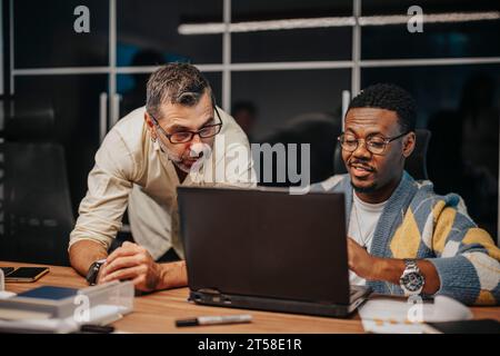 Ein vielseitiges Team von Geschäftsleuten arbeitet in einem modernen Büro zusammen, um gemeinsam Projekte zu entwickeln und das Gewinnwachstum zu planen. Stockfoto