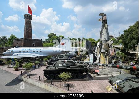 VIETNAM, Hanoi, Militärmuseum, Militärausrüstung und Kriegsschrott aus dem französischen Kolonialkrieg 1946-1954 und dem US-amerikanischen Krieg in Vietnam 1955–1975, US-Kampfpanzer M-48 Patton, US M107 175MM selbstfahrende Haubitze, vietnamesisches Flugzeug und Wrack von Grumman F6F Hellcat ein amerikanisches Trägerflugzeug der französischen Kolonialarmee, abgeschossen bei der Schlacht in Dien Bien Phu 1954, hinter Fahnenturm / VIETNAM, Hanoi, Militär Museum, Ausstellung mit Rüstung und Waffen zu den Kriegen der Franzosen und Amerikaner in Vietnam, hinterer Flaggenturm der alten kaiserlichen Festung Stockfoto