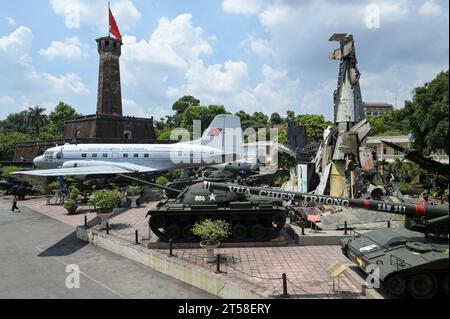 VIETNAM, Hanoi, Militärmuseum, Militärausrüstung und Kriegsschrott aus dem französischen Kolonialkrieg 1946-1954 und dem US-amerikanischen Krieg in Vietnam 1955–1975, US-Kampfpanzer M-48 Patton, US M107 175MM selbstfahrende Haubitze, vietnamesisches Flugzeug und Wrack von Grumman F6F Hellcat ein amerikanisches Trägerflugzeug der französischen Kolonialarmee, abgeschossen bei der Schlacht in Dien Bien Phu 1954, hinter Fahnenturm / VIETNAM, Hanoi, Militär Museum, Ausstellung mit Rüstung und Waffen zu den Kriegen der Franzosen und Amerikaner in Vietnam, hinterer Flaggenturm der alten kaiserlichen Festung Stockfoto