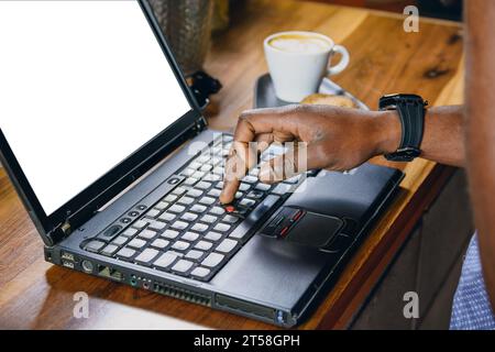 Nahaufnahme der Hand eines nicht erkennbaren schwarzen Mannes, der am Laptop über der Bar im Restaurant, Technologiekonzept, Kopierraum arbeitet. Stockfoto