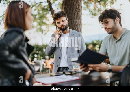 Geschäftsleute sprechen über Strategie, Wachstum und Umsatz in einem geschäftigen städtischen Umfeld. Sie analysieren Budgets, verwalten Risiken und planen den Erfolg. Stockfoto