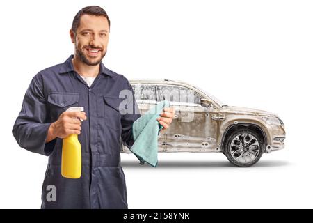 Arbeiter, der ein Wischtuch und ein Reinigungsspray vor einem SUV mit Seifenschaum auf weißem Hintergrund hält Stockfoto