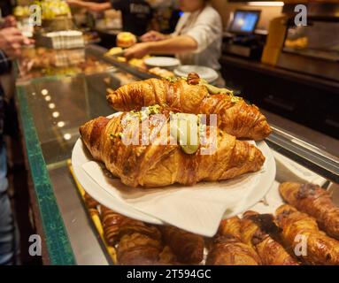 Nahaufnahme - Auswahl an frisch gebackenen Croissants, die an der Theke, auf dem Markt, im Café oder in der Bäckerei verkauft werden. Dessert, Gebäck, Frühstück, süßes Essen und Stockfoto