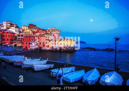 Fantastischer Blick auf den Sonnenuntergang vom alten Fischerdorf Boccadasse in Genua Vorort und auf den Mond am Himmel, viele Boote, die auf dem Boden rosa und gelbe Fishe schützen Stockfoto