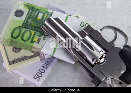 Eine Revolver-Pistole liegt auf einem Stapel Geld und schafft eine illustrative Szene, die Verbrechen und Bargeld symbolisiert Stockfoto