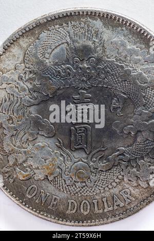 Makro einer 1-Dollar-Münze mit einem Drachen und asiatischem Text in der Mitte. Stockfoto