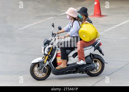 SAMUT PRAKAN, THAILAND, 03. November 2023, zwei Frauen tragen Fracht auf einem Motorrad Stockfoto