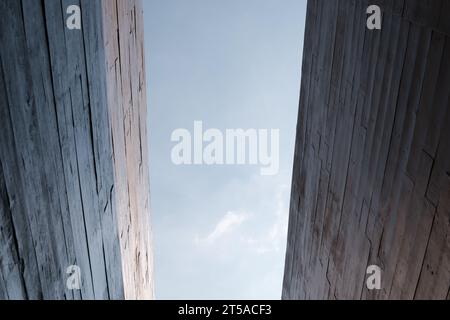 Moderne Wände aus Betonplatten werden auf einem architektonischen Gebäude vor einem klaren blauen Himmel angebracht Stockfoto