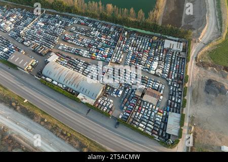 Luftaufnahme des großen Parkplatzes von Schrottplatz mit Reihen von weggeworfenen gebrochenen Autos. Recycling von Altfahrzeugen Stockfoto