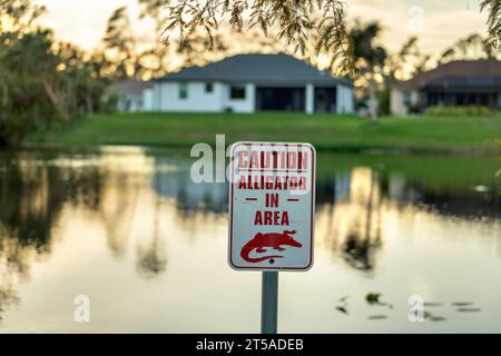 Alligatorwarnschild im Florida Park über Vorsicht und Sicherheit beim Laufen in der Nähe des Wassers Stockfoto