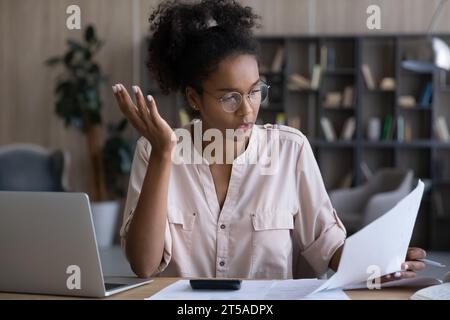 Ernsthafte Schwarze liest falsche Finanzpapiere Stockfoto