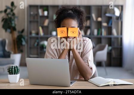 Müde afro-amerikanische Millennial-Studentin schläft am Arbeitsplatz Stockfoto