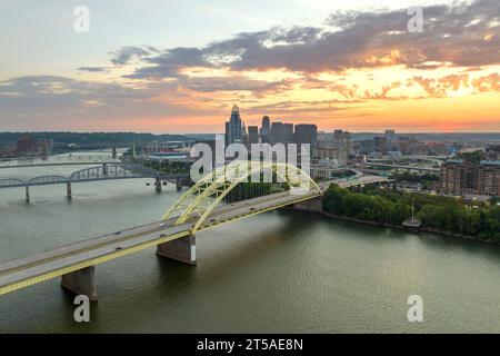 Straßenverkehr mit fahrenden Autos auf der Brücke im Stadtteil Cincinnati in Ohio, USA. Amerikanische Skyline mit hell erleuchteten Höhen Stockfoto