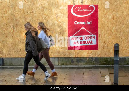 Leute, die an Clinton Cards vorbeikamen, gingen an Bord des Souvenirgeschäfts in Southport, Großbritannien. Geschäfte, Shopper, Shopping in Chapel Street, Southport, Großbritannien Stockfoto