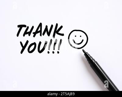 Danksagung mit einem handgezeichneten lächelnden Emoticon-Gesicht auf weißem Hintergrund. Dankbarkeit Konzept. Stockfoto