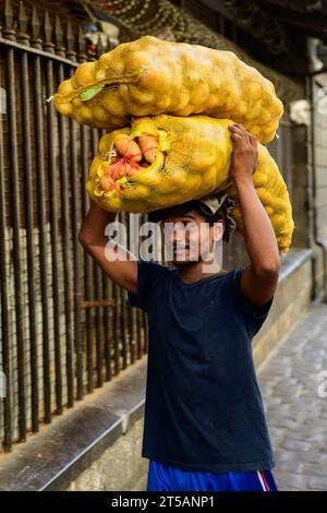 Port Louis, Mauritius - 25. Oktober 2023: Porter oder Träger mit Kartoffelsäcken auf dem Central Market Stockfoto