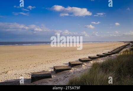 Blick nach Süden vom Friasthorpe Beach in der Nähe von Bridlingron. Die Betonblöcke entlang des Strandes sind Relikte aus dem Zweiten Weltkrieg (2. Weltkrieg). Stockfoto