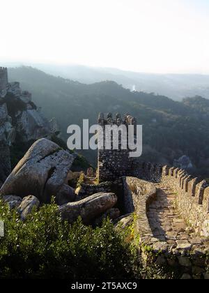 Mittelalterliches Castelo dos Mouros, auch bekannt als Schloss der Mauren in Sintra, Portugal. Wachtürme und Verteidigungsmauern, die den Bergrücken mit einem Wettkampf hinaufklettern Stockfoto