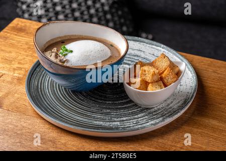 Köstliches Mittagessen, beruhigende Pilzcreme-Suppe, serviert mit knusprigem Brot. Köstlich. Gericht in einem Restaurant, Menü-Food-Konzept. Stockfoto