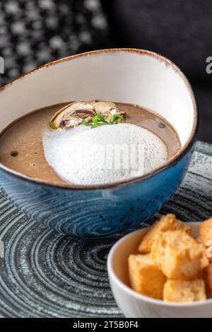 Köstliches Mittagessen, beruhigende Pilzcreme-Suppe, serviert mit knusprigem Brot. Köstlich. Gericht in einem Restaurant, Menü-Food-Konzept. Stockfoto