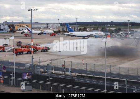 Köln, Deutschland. November 2023. Flugfeldfeuerwehrmaschinen löschen zwei Flugzeuge, die während einer Notfallübung Feuer gefangen haben. Auf den Flughäfen werden regelmäßig Übungen durchgeführt, um sicherzustellen, dass die Verfahren im Notfall reibungslos ablaufen. Quelle: dpa/Alamy Live News Stockfoto