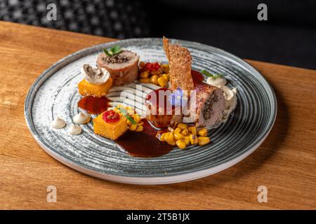 Kaninchenbrötchen mit Pilzen, Polenta und Berblansauce. Köstlich. Gericht in einem Restaurant, Menü-Food-Konzept. Stockfoto