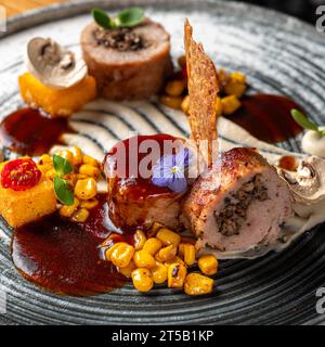 Kaninchenbrötchen mit Pilzen, Polenta und Berblansauce. Köstlich. Gericht in einem Restaurant, Menü-Food-Konzept. Stockfoto