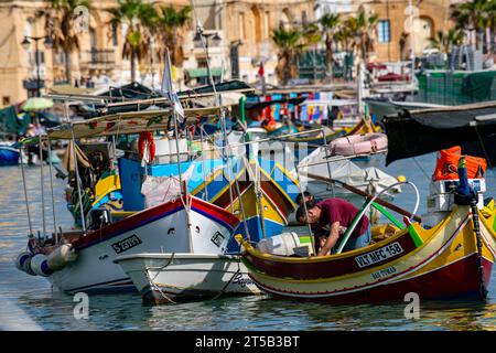 Die bunten Boote im Hafen von Marsaxlokk und der Kirche unserer Lieben Frau. Malta Stockfoto