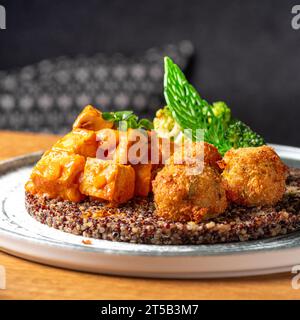 Buddha-Schüssel mit Quinoa, Brokkoli und Pilz-Tofu-Sauce. Gesunde Ernährung, gesunde Lebensweise, vegane Ernährung, vegetarische Ernährung. Essen in einem Restaurant serviert Stockfoto