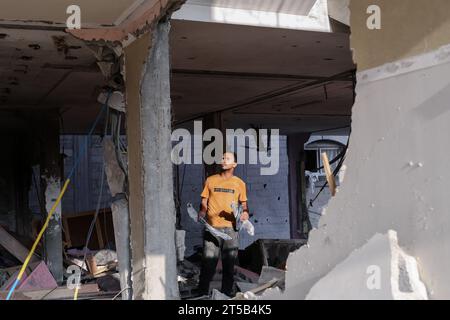 Gaza, Palästina. November 2023. Ein palästinensischer Mann hält Bruchstücke einer israelischen Rakete in den Trümmern eines Hauses, das durch israelische Angriffe in Khan Yunis zerstört wurde. Tausende von Zivilisten, sowohl Palästinenser als auch Israelis, sind seit dem 7. Oktober 2023 gestorben, nachdem palästinensische Hamas-Militante im Gazastreifen in den Süden Israels einmarschierten, bei einem beispiellosen Angriff, der einen Krieg auslöste, den Israel gegen die Hamas mit Vergeltungsbomben auf Gaza erklärt hatte. Quelle: SOPA Images Limited/Alamy Live News Stockfoto