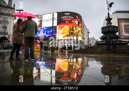 Leute mit Regenschirmen bei nassem Wetter im Piccadilly Circus, London. Die Überschwemmungsgefahr im Süden Englands ist nach wie vor hoch, da Großbritannien die Folgen des verheerenden Sturms Ciaran spürt und das extreme Wetter voraussichtlich Regengüsse und starke Winde nach Schottland und Teilen Nordenglands bringen wird. Bilddatum: Samstag, 4. November 2023. Stockfoto