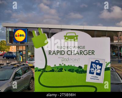 Auffällige Beschilderung an einer Schnellladestelle für Elektrofahrzeuge auf einem Kundenparkplatz bei einer Filiale des deutschen Discount-Supermarktes Lidl. Stockfoto