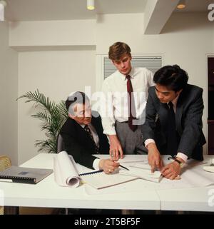 Unternehmen. Drei Männer im Amt diskutieren Dokumente und Pläne. Stockfoto