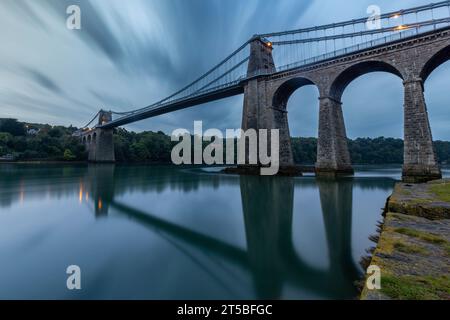 Die berühmte Menai Bridge, eine Hängebrücke, die von Thomas Telford entworfen und im 19. Jahrhundert erbaut wurde. Die Brücke überspannt die Menai-Straße und verbindet m Stockfoto