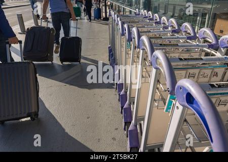 Reihe von Gepäckwagen oder Gepäckwagen oder Flughafenwagen mit Personen oder Touristen. Hintergrundfoto des Reisekonzepts. Stockfoto