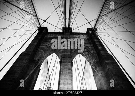 Ein atemberaubendes Stockfoto der berühmten Brooklyn Bridge, eines der beliebtesten Reiseziele von New York City. Das Foto zeigt den Gracef der Brücke Stockfoto