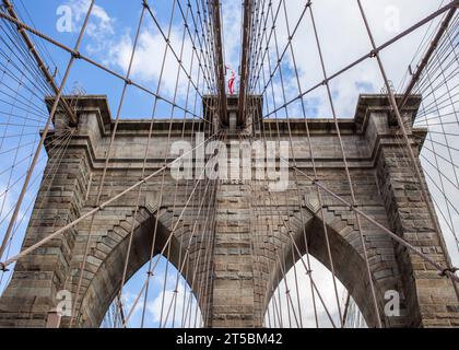 Ein atemberaubendes Stockfoto der berühmten Brooklyn Bridge, eines der beliebtesten Reiseziele von New York City. Das Foto zeigt den Gracef der Brücke Stockfoto